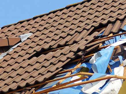 The image shows a team of professionals from E.W. MacDowell Roofing working on repairing a roof damaged by a storm in West Palm Beach. They are equipped with the necessary tools and safety gear, and are focused on completing the repair work efficiently and effectively. The image aims to showcase the company's expertise and experience in handling roof storm damage repair projects.